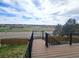 Wide planked deck with black metal railings overlooking beautiful green space under blue skies at 21580 Longs Peak Ln, Parker, CO 80138