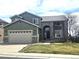 Inviting two-story home boasts stone accents, lush lawn, and attached two car garage at 21580 Longs Peak Ln, Parker, CO 80138