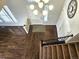 Elegant foyer with hardwood floors, staircase with carpet runner, and stylish lighting fixture at 21580 Longs Peak Ln, Parker, CO 80138
