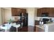 Eat-in kitchen featuring dark wood cabinets, stainless steel appliances, granite counters, and hardwood floors at 21580 Longs Peak Ln, Parker, CO 80138