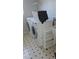 Practical laundry room with a front-load washer and dryer, plus storage space on a patterned floor at 21580 Longs Peak Ln, Parker, CO 80138