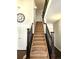 Carpeted staircase with stained wood banister and spindles leading to the upper level of the home at 21580 Longs Peak Ln, Parker, CO 80138