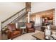 Well-lit living room with elegant staircase, cozy seating, and view into the kitchen area at 22435 Boundstone Dr, Parker, CO 80138