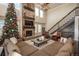 Inviting living room with a stone fireplace, decorated staircase, and festive Christmas decor at 22435 Boundstone Dr, Parker, CO 80138