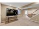 Finished basement with a large TV and a staircase to the upper level at 4539 Lyndenwood Cir, Highlands Ranch, CO 80130