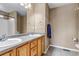 Well-lit bathroom with dual sinks, oak cabinets, and neutral walls at 4539 Lyndenwood Cir, Highlands Ranch, CO 80130
