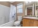 Cozy bathroom featuring a tub with a shower, toilet, and single sink vanity at 4539 Lyndenwood Cir, Highlands Ranch, CO 80130
