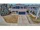 Captivating two-story home with a blue exterior, brick accents, covered front porch, and concrete driveway at 4539 Lyndenwood Cir, Highlands Ranch, CO 80130
