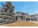 Beautiful home with blue siding, brick accents, and a lush evergreen tree in the front yard at 4539 Lyndenwood Cir, Highlands Ranch, CO 80130