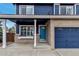 Inviting front porch with classic white columns, blue front door, and brick accents at 4539 Lyndenwood Cir, Highlands Ranch, CO 80130