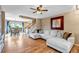 Bright living room with hardwood floors, a cozy sectional sofa, and a view into the dining area at 4539 Lyndenwood Cir, Highlands Ranch, CO 80130