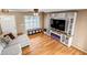 Inviting living room with modern entertainment center, hardwood floors, and ample natural light at 4539 Lyndenwood Cir, Highlands Ranch, CO 80130
