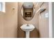 Stylish powder room with pedestal sink, oval mirror, and neutral paint at 4539 Lyndenwood Cir, Highlands Ranch, CO 80130