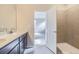 A bright bathroom featuring a double sink vanity and a view of the shower at 735 Sunflower Dr, Brighton, CO 80601