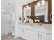 Well-lit bathroom featuring double sinks, sleek white cabinetry, and a glass-enclosed shower at 924 Andrews Crest Dr, Berthoud, CO 80513