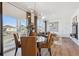 Bright dining area with modern chandelier, wood floors, neutral tones, and access to the balcony at 924 Andrews Crest Dr, Berthoud, CO 80513