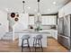 Bright kitchen features stainless appliances, white cabinets, hardwood floors, and a kitchen island with seating at 924 Andrews Crest Dr, Berthoud, CO 80513