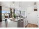 Kitchen island with sink, stainless dishwasher, and an open view to dining and living room at 924 Andrews Crest Dr, Berthoud, CO 80513