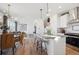 Open concept kitchen with island seating, stainless appliances, and view into the dining and living areas at 924 Andrews Crest Dr, Berthoud, CO 80513