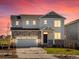Home exterior at dusk with stone accents, lawn and a two-car garage at 1935 Coolidge Way, Aurora, CO 80018