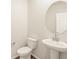 Well-lit powder room features a modern pedestal sink and toilet with a round mirror at 1935 Coolidge Way, Aurora, CO 80018