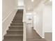 Carpeted staircase with white railings leads to the upper level, with hardwood flooring at the base at 1935 Coolidge Way, Aurora, CO 80018