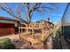 A wood deck with table and chairs is adjacent to a fenced grassy yard with storage building in the background at 241 N Grant St, Denver, CO 80203