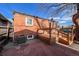 Backyard with brick building, wood deck and fence, and reddish-brown stone patio floor at 241 N Grant St, Denver, CO 80203