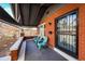 Inviting front porch with red brick, security door, and three chairs for relaxing at 241 N Grant St, Denver, CO 80203