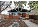 Charming brick home featuring a landscaped front yard, stone walkway, and flowering trees at 241 N Grant St, Denver, CO 80203