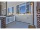 Inviting front porch with a seating area, white picket fence and brick accents at 15530 W 64Th Pl # C, Arvada, CO 80007