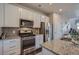 Modern kitchen featuring granite countertops, stainless steel appliances and white cabinetry at 15530 W 64Th Pl # C, Arvada, CO 80007