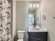 Cozy bathroom with a vanity, toilet, and shower featuring a textured shower curtain at 607 Azalea St, Brighton, CO 80601