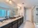 Bathroom with a double vanity, granite countertops, tiled floors, and a separate shower and tub at 607 Azalea St, Brighton, CO 80601
