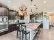Spacious kitchen with an island, granite countertops, dark cabinetry, and hardwood flooring at 607 Azalea St, Brighton, CO 80601