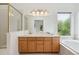 Bathroom featuring double sinks, a soaking tub, and a glass enclosed shower at 11237 W Ford Dr, Lakewood, CO 80226