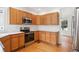 Kitchen featuring stainless steel appliances, light wood cabinets and hardwood floors at 11237 W Ford Dr, Lakewood, CO 80226