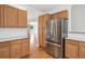 Kitchen featuring stainless refrigerator, light wood cabinets and hardwood floors at 11237 W Ford Dr, Lakewood, CO 80226