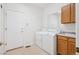 Bright laundry room with washer, dryer, and built in cabinets at 11237 W Ford Dr, Lakewood, CO 80226
