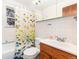 Bathroom featuring a tub with shower, white tile, and a wood vanity at 2635 Julian St, Denver, CO 80211