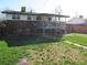 View of the backyard with a well-maintained lawn and a two-story home with a deck at 827 Hannibal Dr, Aurora, CO 80011