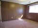 A small bedroom with wood paneling, and a window that lets in natural light at 827 Hannibal Dr, Aurora, CO 80011