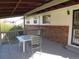 Covered deck features a table and chairs with outdoor seating for relaxing and entertaining at 827 Hannibal Dr, Aurora, CO 80011