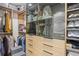 Organized walk-in closet features custom shelves, glass-door storage, and soft closing drawer units at 3232 W 16 Ave, Denver, CO 80204