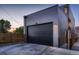 Spacious garage with modern design elements, gray siding, and a secure black door at 3232 W 16 Ave, Denver, CO 80204