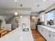 Contemporary kitchen with white cabinets, stone countertops, stainless steel appliances, and hardwood floors at 6162 W 28Th Ct, Wheat Ridge, CO 80214