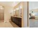 Luxurious bathroom with triple vanity, large mirrors, and tile flooring at 7172 S Oakleaf St, Bennett, CO 80102