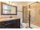 Bathroom features a spacious shower, dark wood vanity, and decorative mirror at 7172 S Oakleaf St, Bennett, CO 80102