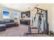 Bonus room is furnished with comfortable seating, wet bar, and exercise equipment at 7172 S Oakleaf St, Bennett, CO 80102