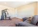 Bonus room is furnished with comfortable seating and exercise equipment at 7172 S Oakleaf St, Bennett, CO 80102